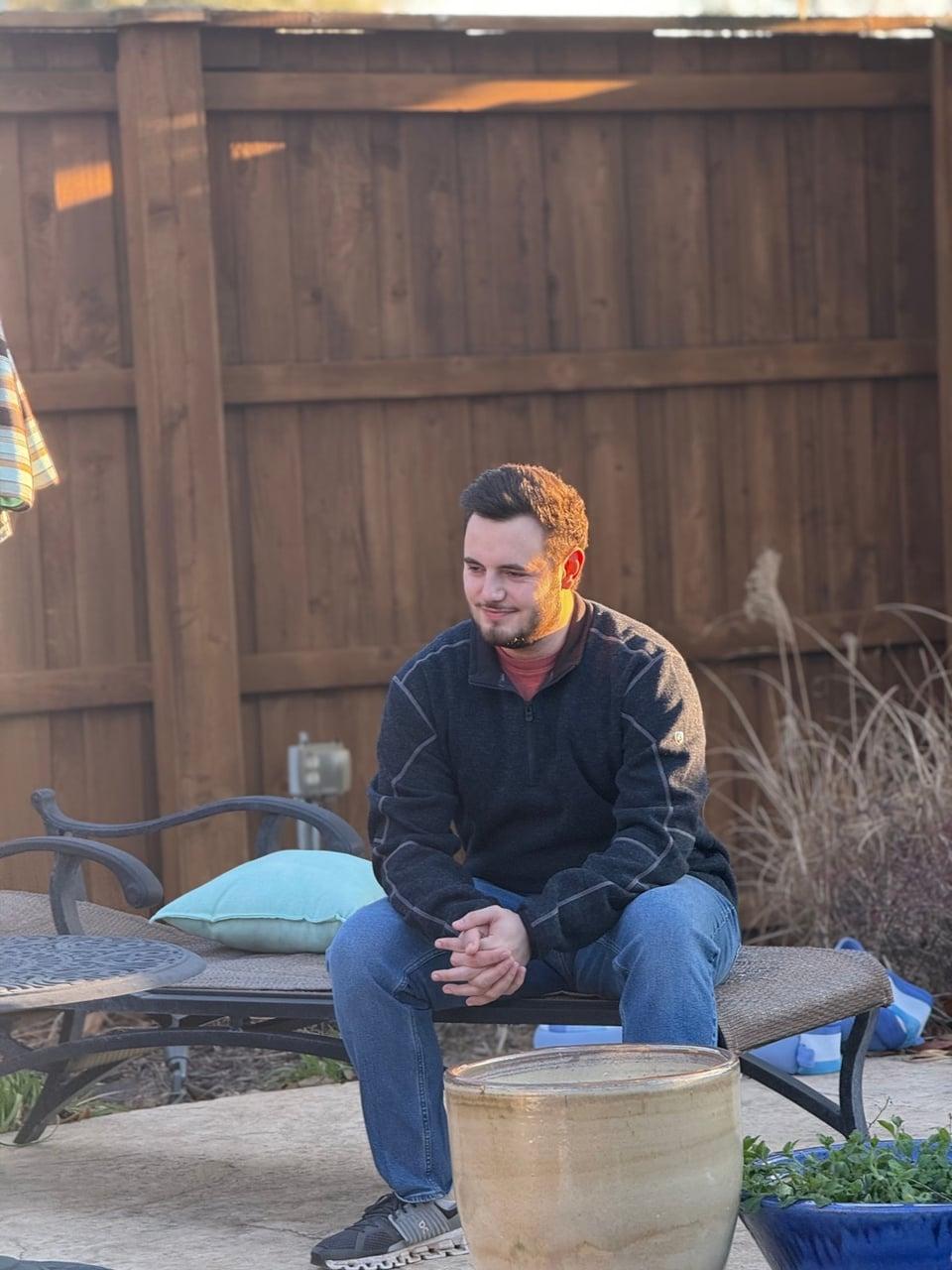 Christopher seated outdoors